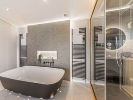 A bathroom with a bathtub and shower area at The Sheraton Retreat in Wigton