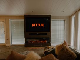 A living room with a television displaying NETFLIX at The Sheraton Retreat in Wigton