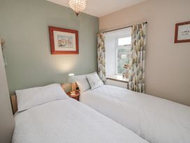 A bedroom with two single beds and a window at 21 High Street Scarborough