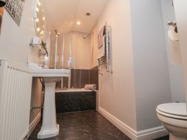 A bathroom with a sink, toilet, shower stall, and towel rack at 21 High Street Scarborough