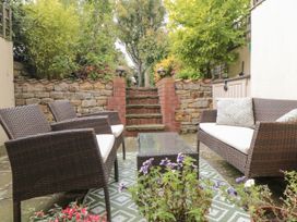 A patio area with chairs, a table, and steps at 21 High Street, Scarborough