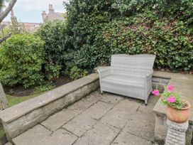 A garden with a bench and flower pot at 21 High Street Scarborough
