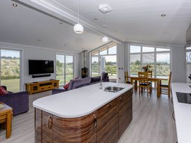 A living room with a kitchen island and dining area at Wordsworth in Wigton