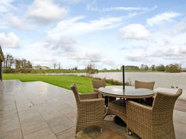 An outdoor area with a table and chairs by a lake at Lawson in Wigton