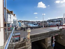 A view of the harbor with boats and buildings at Harbourside Apartment in Weymouth