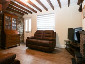 A living room with a sofa and television at 6 Berry Street in Conwy