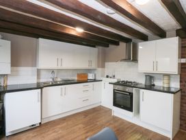 A kitchen with cabinets and appliances at 6 Berry Street in Conwy