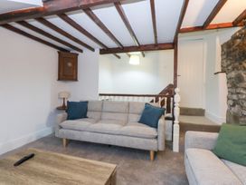 A living room with a sofa and wooden beams at 6 Berry Street in Conwy