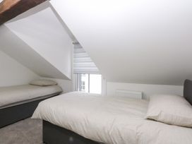 A bedroom with two beds and a window at 6 Berry Street in Conwy