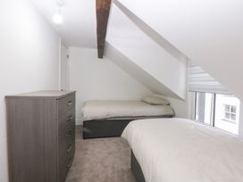 A bedroom with two beds and a dresser at 6 Berry Street Conwy