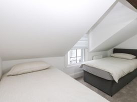 A bedroom with two beds and a window at 6 Berry Street in Conwy