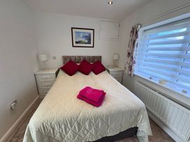 A bedroom with a bed and bedside tables at Ty Nain in Bodorgan