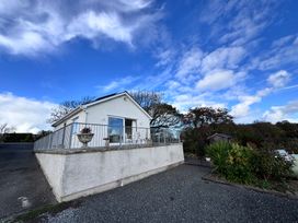 A house with a railing and planter in the yard at Ty Nain in Bodorgan