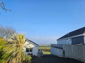 An outdoor view of two houses with a clear sky at Ty Nain Bodorgan