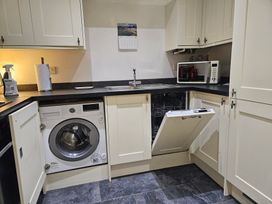 A kitchen with a washing machine and dishwasher at Ty Nain in Bodorgan