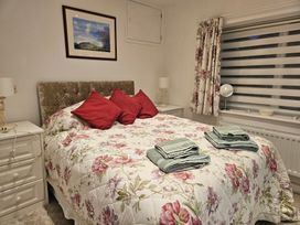 A bedroom with a bed and bedside tables at Ty Nain Bodorgan