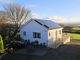 A house with solar panels and outdoor seating area at Ty Nain in Bethel
