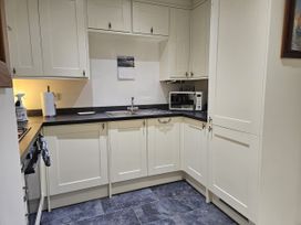 A kitchen with a sink and microwave at Ty Nain Bethel