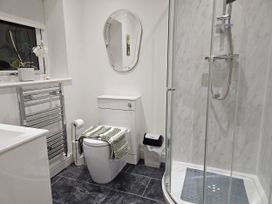 A bathroom with a toilet, sink, and shower at Ty Nain in Bethel