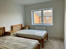 A bedroom with two beds and a window at 12 Brewhouse Place Weymouth