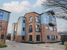 A brick apartment building with balconies and parking at Brewery View in Weymouth