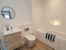 A bathroom with a bathtub, toilet, and sink at Brewery View in Weymouth