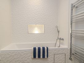 A bathroom with a bathtub and showerhead at Brewery View in Weymouth