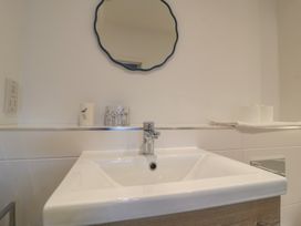 A sink with a mirror and toiletries at Brewery View in Weymouth