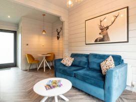 A living room with a blue sofa and a dining area at Askrigg (Pet) Aysgarth