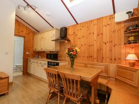 A kitchen with cabinets, dining table, and appliances at The Log Cabin in Corse near Gloucester