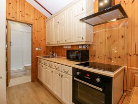 A kitchen with cabinets, sink, microwave and oven at The Log Cabin in Corse near Gloucester