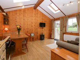 A living room featuring a dining table and chairs at The Log Cabin in Corse near Gloucester