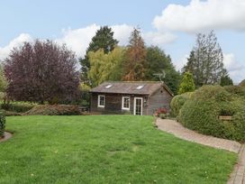A garden with a wooden shed and pathway at The Log Cabin in Corse near Gloucester