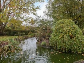 A pond with a duck and shrubs at The Log Cabin Corse near Gloucester