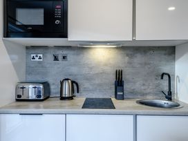 A kitchen with a microwave toaster kettle and sink at Somersby Spa in Louth