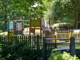 A playground with equipment and a fence at Wensleydale Aysgarth