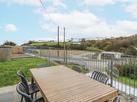 An outdoor area with a wooden table and chairs at Fronglyd in Aberporth