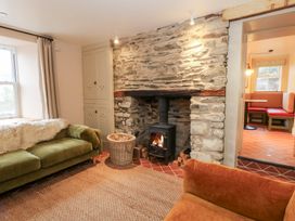 A living room with a fireplace and seating area at Fronglyd Aberporth