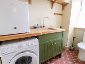 A laundry room with a washing machine and sink at Fronglyd Aberporth