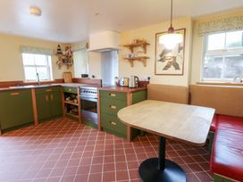A kitchen with a table, kettle, and oven at Fronglyd in Aberporth