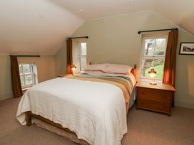 A bedroom with a bed and windows at Fronglyd in Aberporth