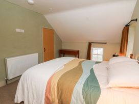 A bedroom with a bed, radiator, table and window at Fronglyd Aberporth