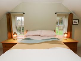 A bedroom with a bed and lamps at Fronglyd Aberporth