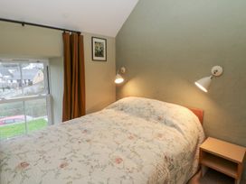 A bedroom with a bed and nightstand at Fronglyd, Aberporth