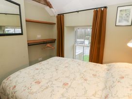 A bedroom with a bed and a shelf at Fronglyd Aberporth