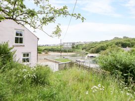 A house with grass and a path near water at Fronglyd Aberporth