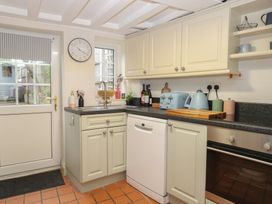 A kitchen with appliances and a door at Beeble Cottage in Fakenham
