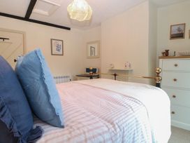 A bedroom with a bed and a dresser at Beeble Cottage in Fakenham