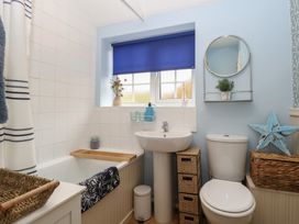 A bathroom featuring a bathtub, toilet, and sink at Beeble Cottage in Fakenham