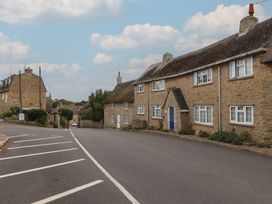 A street with stone houses and a road at Vine Cottage in Burton Bradstock